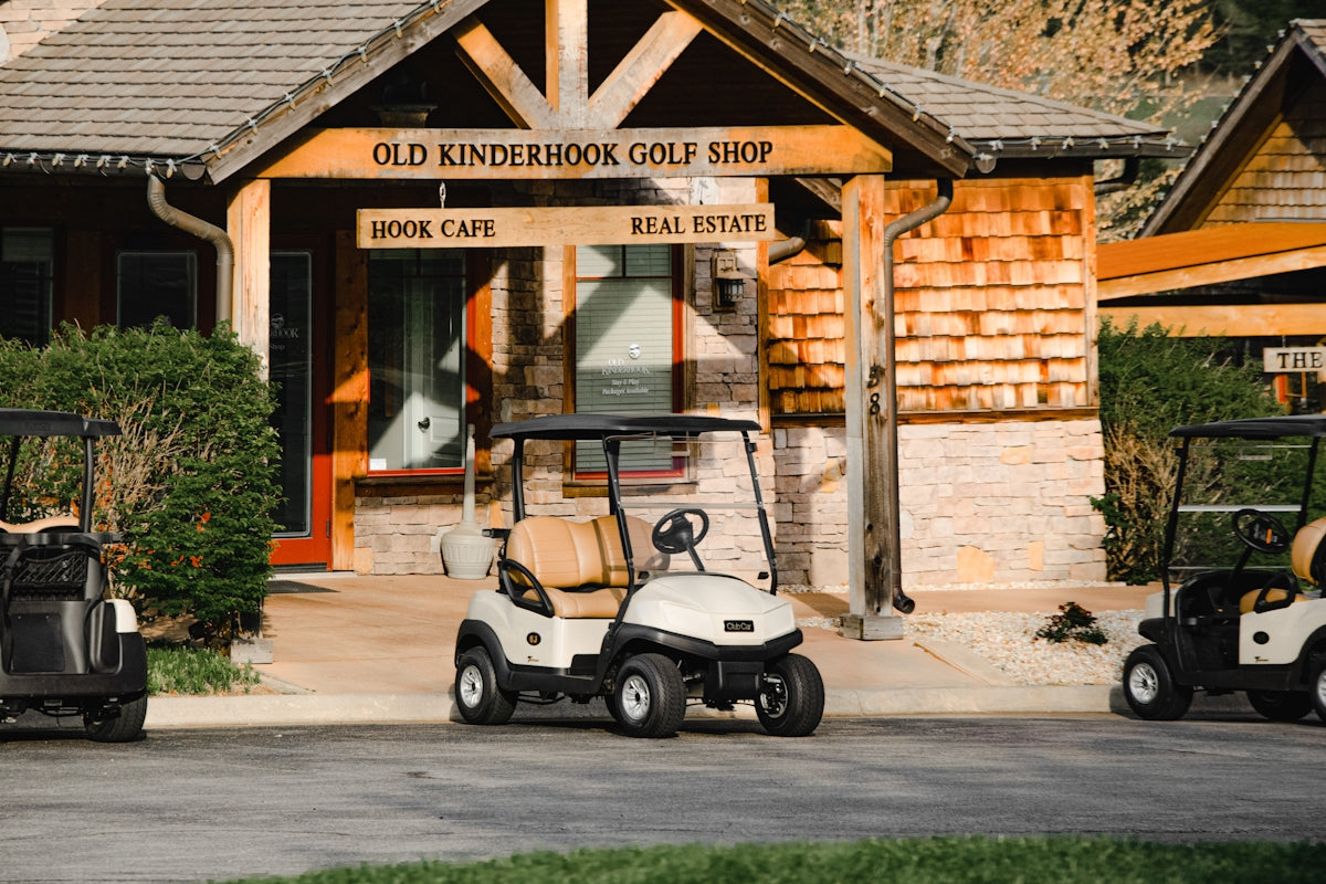 white and black golf cart parked near brown concrete building during daytime