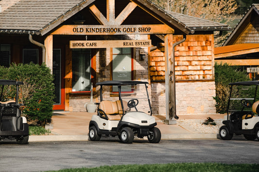 white and black golf cart parked near brown concrete building during daytime