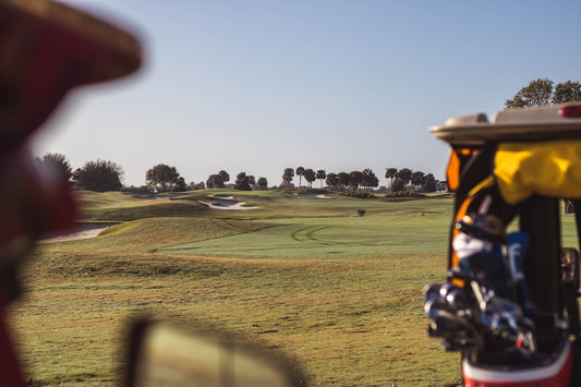 a view of a golf course from the driver's seat of a golf cart