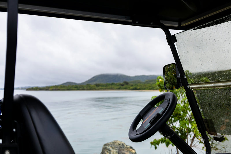 A golf cart offers a watery, mountainous view