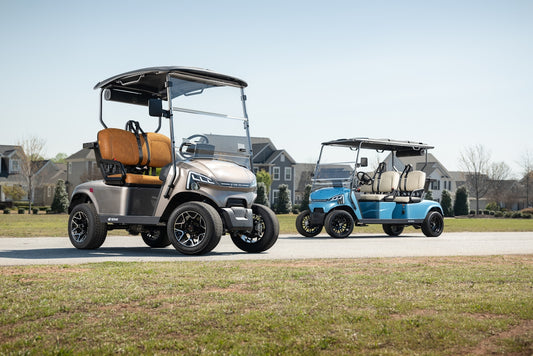 Two golf carts parked on a paved path near houses.