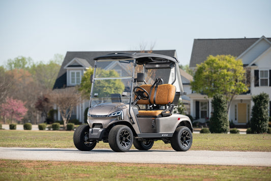 Grey golf cart with brown seats on a residential street.