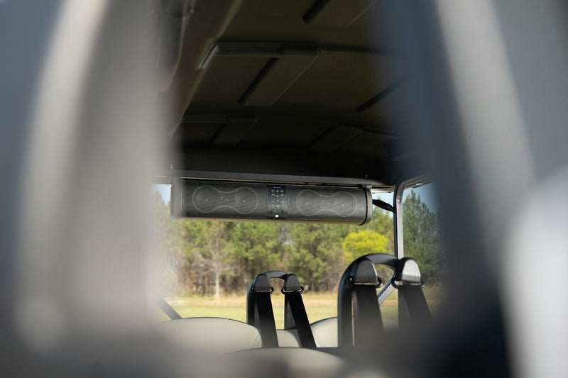 A black soundbar mounted inside a golf cart