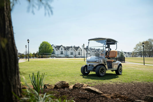 A golf cart parked on a sunny green lawn